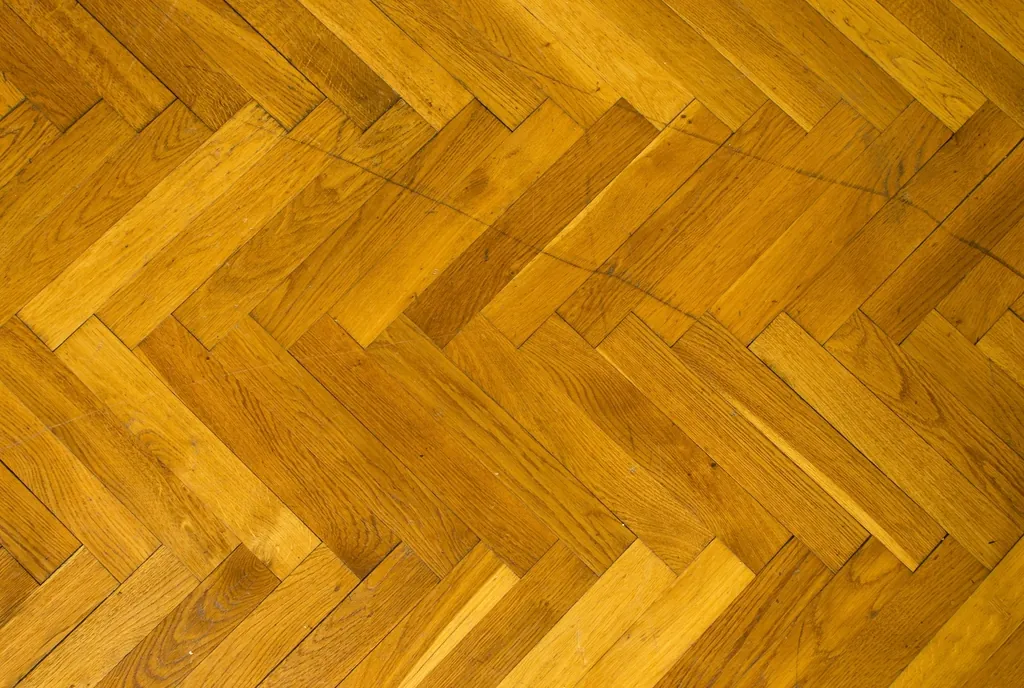Herringbone pattern hardwood floor in warm tones